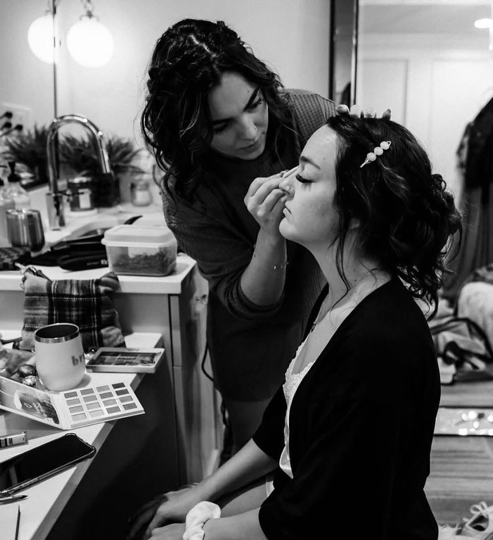 Maddie applying makeup during a cosmetology session